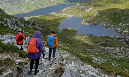 Hikers with Black Girls Hike walk down a mountain towards a couple of lakes
