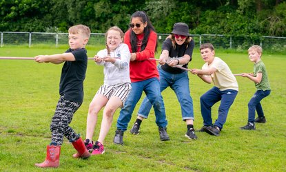 Northern Roots-Group of young people all pulling on a rope together in game