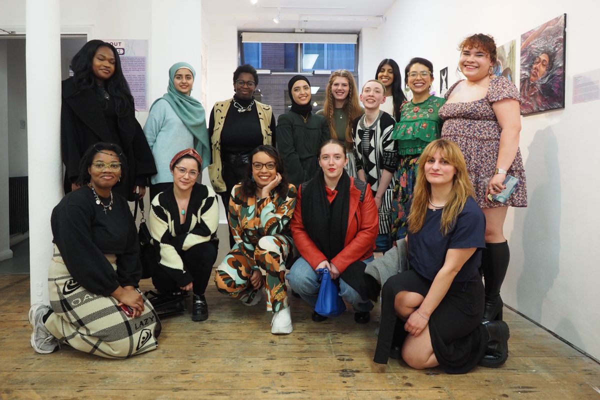 SKAPED-group of young people pose together for a picture in a gallery showing an exhibition of their art.